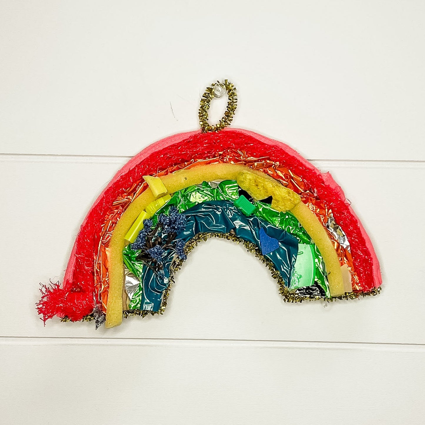 Colorful rainbow-shaped object on a white wooden background